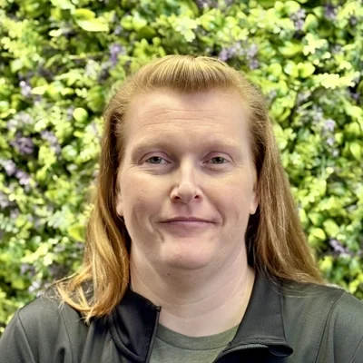 Chiropractic Bloomington IL Kathy Wade Kathy Wade smiling in front of greenery
