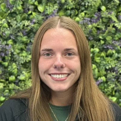 Chiropractic Bloomington IL Lauren Davis Lauren Davis smiling in front of greenery
